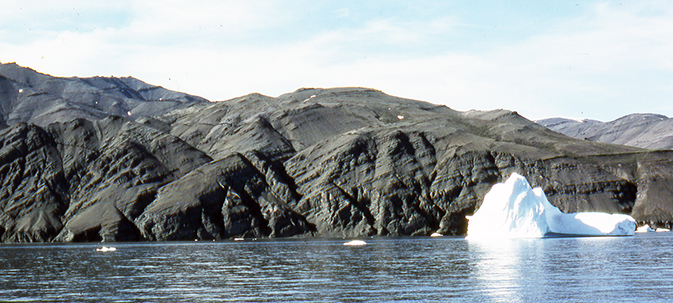 Fig. 33 Well-exposed lavas of the Nunavik Member in the large flexure zone that runs SSE from Usuit Kuussuat to the south coast west of Ulissat (Fig. 6). Over the about 700 m from right to left in the photo, the dip of the lava flows changes from 5°WSW to 30°WSW through two sets of closely spaced faults oriented WNW–SSE and NNW–SSE (Larsen & Pulvertaft 2000). Displacements on the faults are difficult to see due to the monotonous lithology of the Nunavik Member; an interpretation is shown in Fig. 17 (Saviit flexure zone). South coast of Svartenhuk Halvø just west of Ulissat.