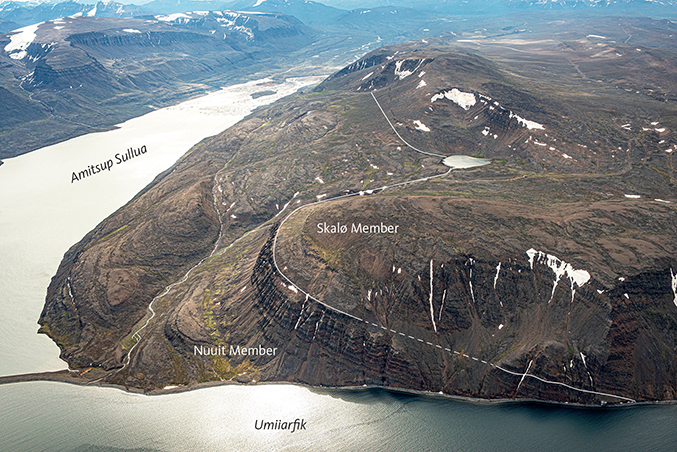 Fig. 59 The upper lava flows of the Nuuit Member and the conformable boundary to the Skalø Member at Amitsoq just west of the Amitsup Sullua inlet, looking SE. The water in the foreground is the Umiiarfik fjord. Note that the lava package west of Amitsup Sullua is tilted 14°W, whereas the lava package east of Amitsup Sullua is nearly flat-lying (Figs 53, 54). Photo: Kristian Svennevig.