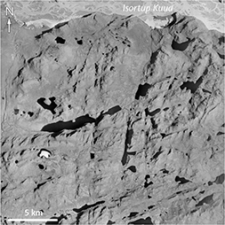 Fig. 13 N–NNE-trending dykes south of the meltwater plain Isortup Kuua. Location in Fig. 3. E–W width of image is 23 km. The nature of exposure does not permit an assessment of dyke density. Only in a few places can a clear colour contrast provide confirmation of a dyke, but terrain lineaments nevertheless suggest the occurrence of a substantial number of dykes. Source: Aerial photo H927.
