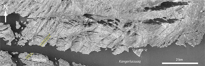 Fig. 21 Aerial photo D3208 showing NE-trending dykes for profile ‘B’ (location in Fig. 3) along the coast north of Simiutaq (lower left) at the mouth of Kangerlussuaq. Yellow dashed lines indicate the outline of a dyke, c. 80 m wide.