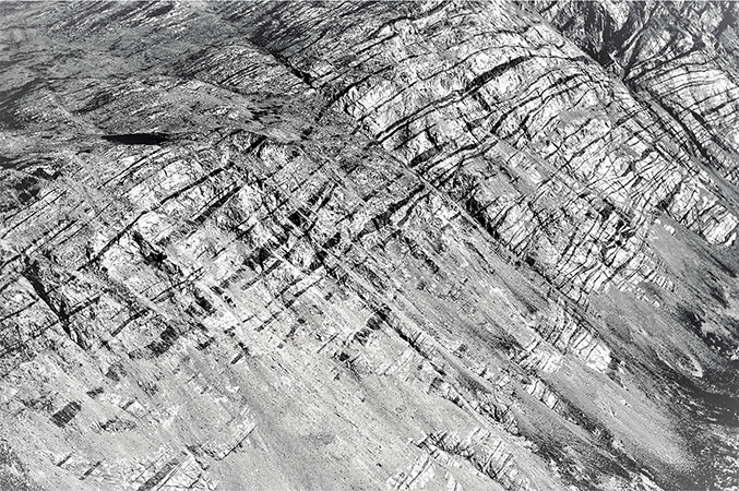 Fig. 29 Extremely deformed dykes are visible in the northern wall (height of section c. 700 m) of Sarfartoq valley (‘Escher’s wall’). This exposure is part of the Paradise thrust segment of Hageskov (1995b) and Olsen (2000). In this wall, c. 50 dykes are visible, and detailed measurements indicate they make up 22% of the exposure. Location in Fig. 3. Valley trends E–W, viewing direction towards the NE.