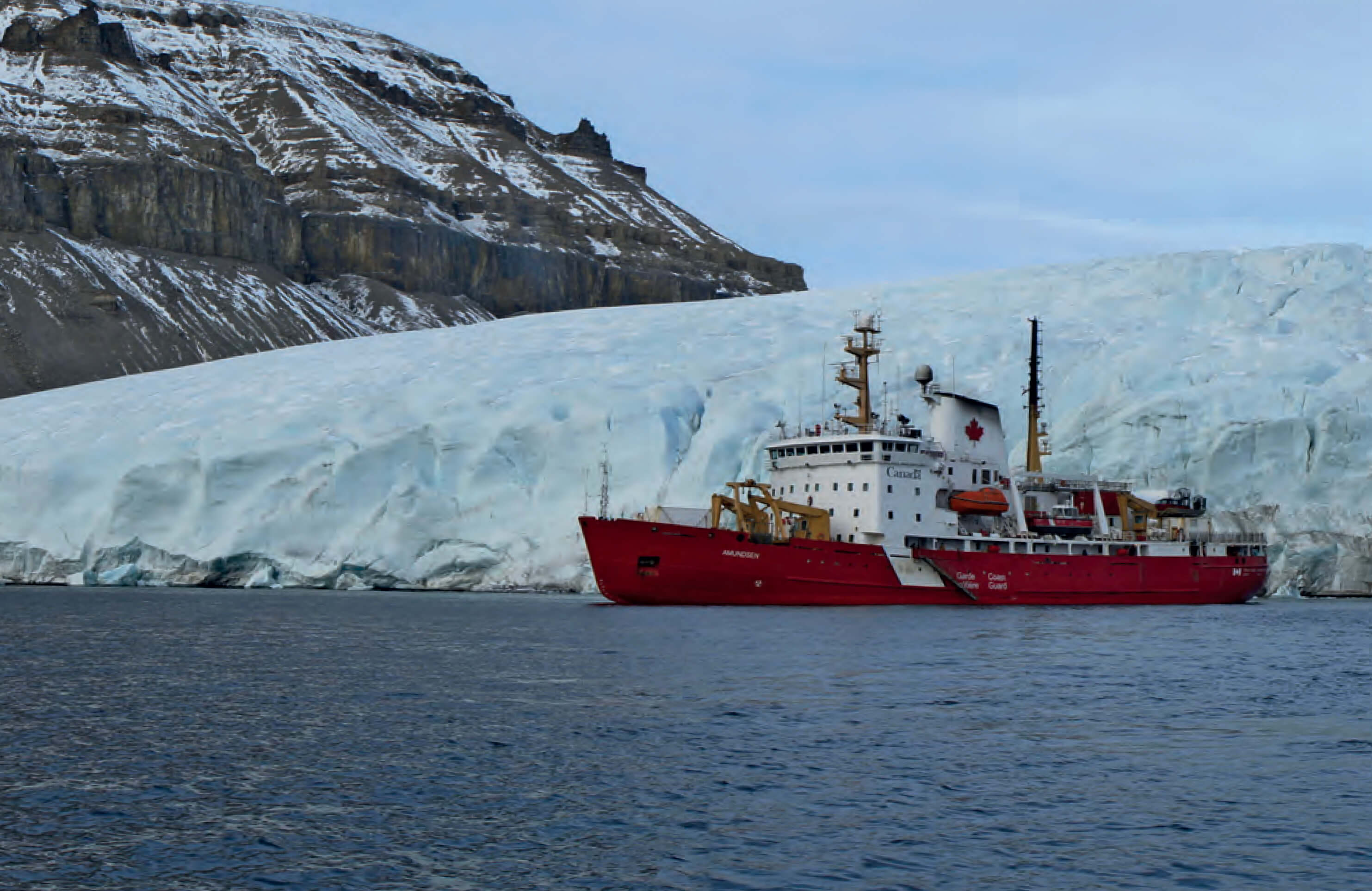 Ship sailing in a fjord with ice behind