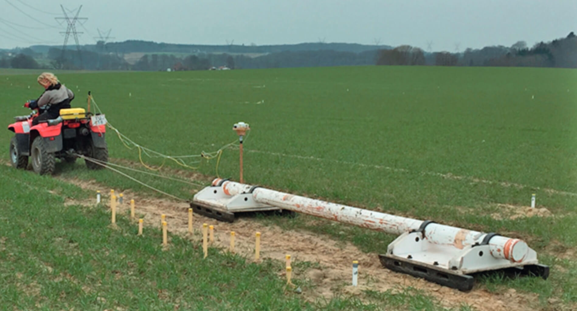 Person drives a vehicle pulling geophysical scanning equipment