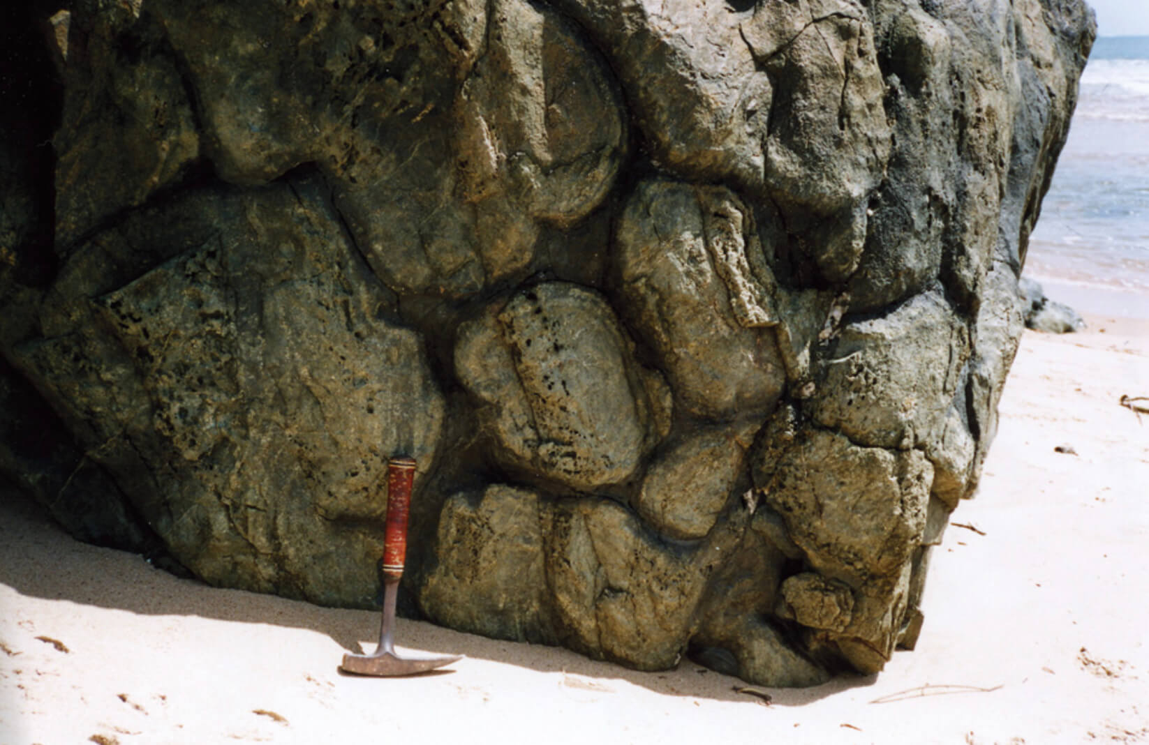 Rock exposure with hammer for scale.