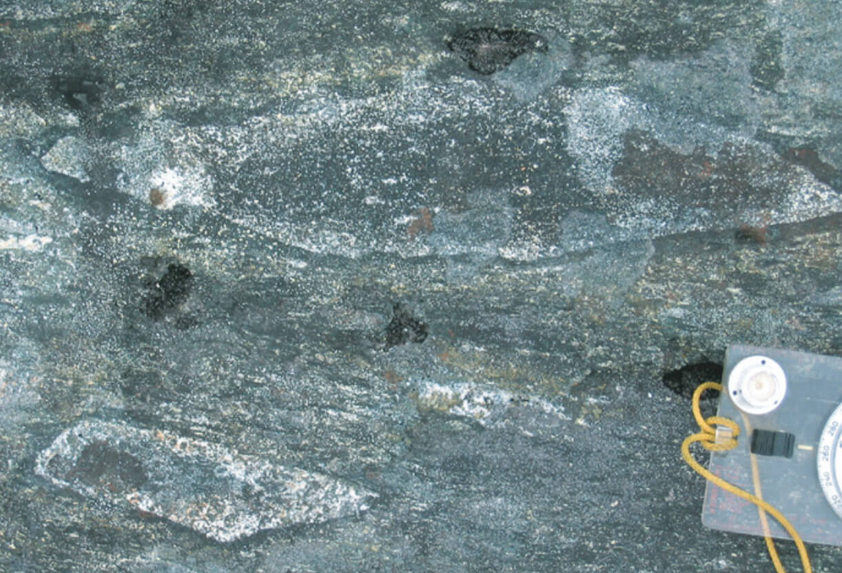 Close up on rock with a compass for scale.