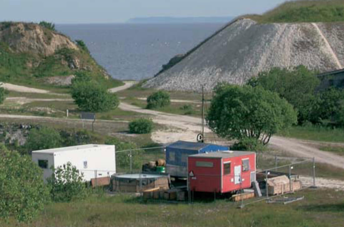 Slag heap with the sea in the background and caravans in foreground.