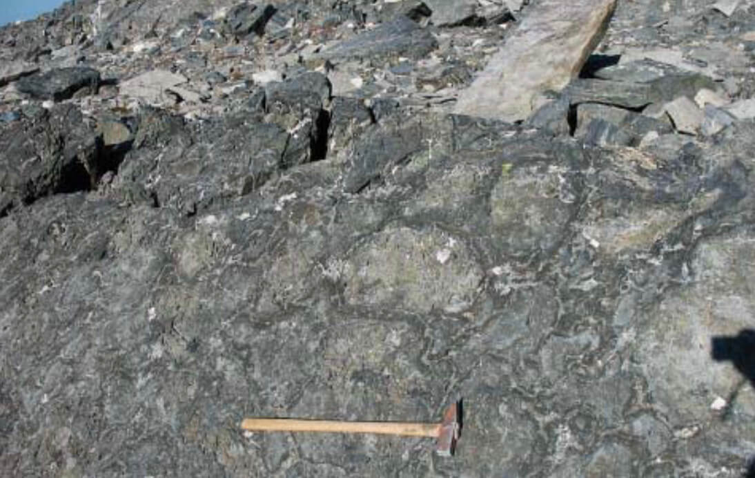 Close up view or rocks with a hammer for scale.