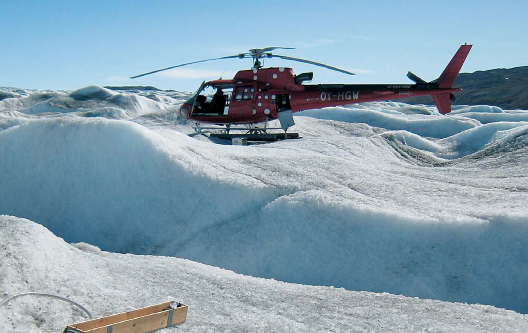 Helicopter lands on glacier.